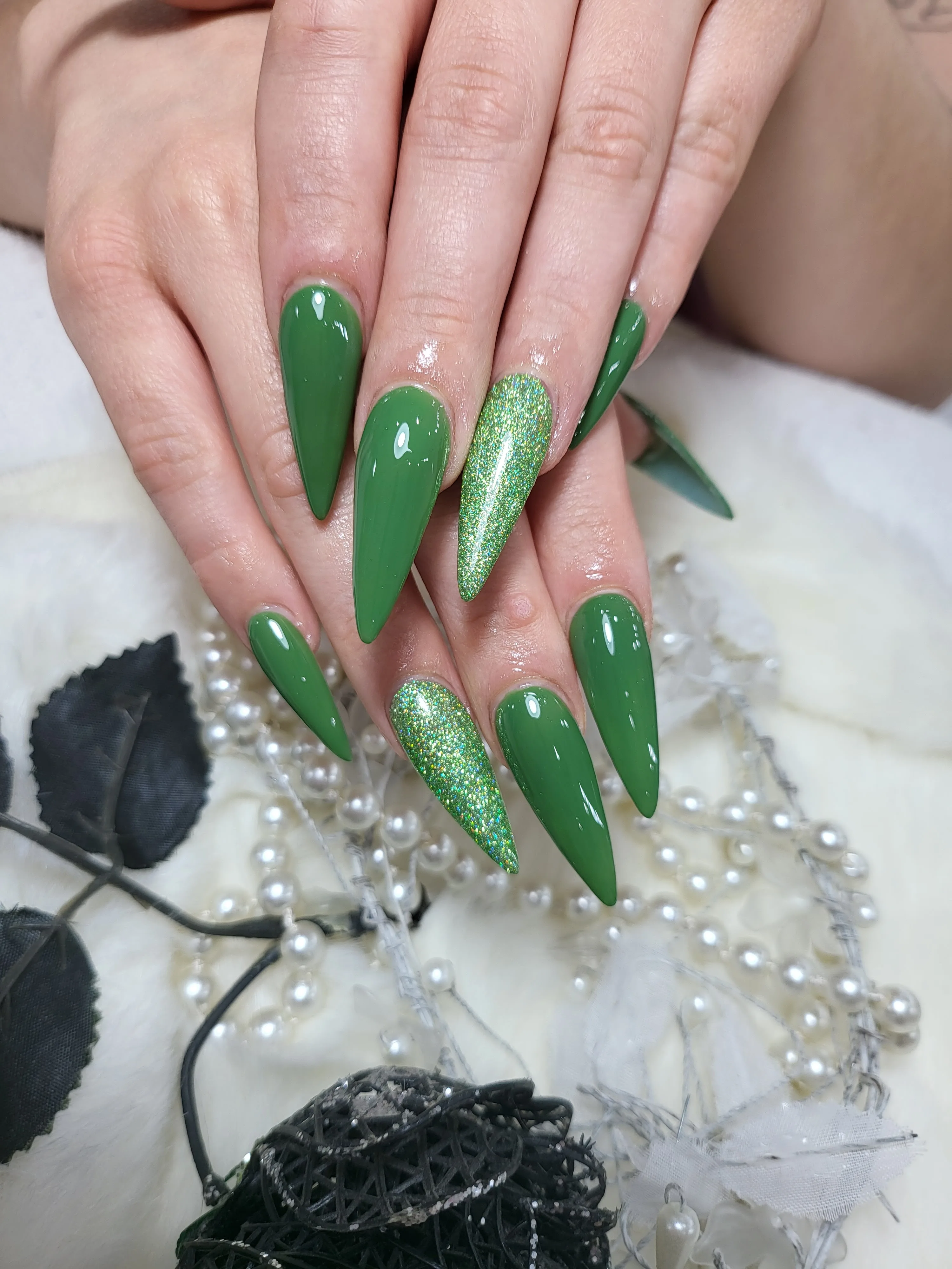 Green stiletto nails with glitter accent nails on pearls